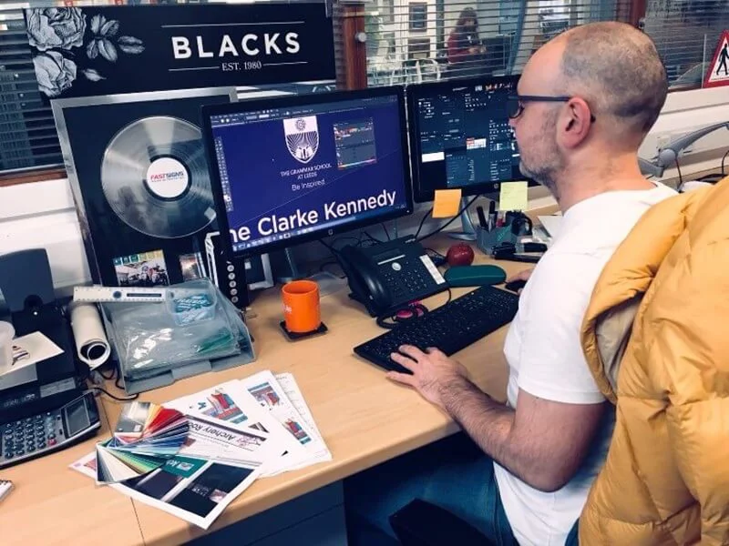 An image of someone designing school signage on a computer.